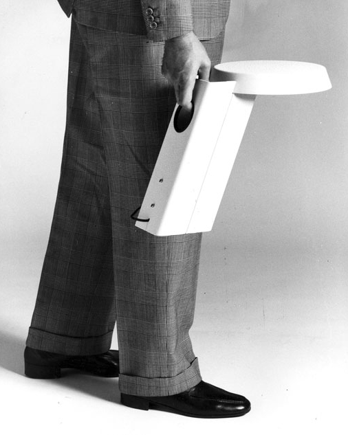 Gino Sarfatti, recognizable in his preferred Prince of Wales suit, demonstrates the use of model 607 (1971)