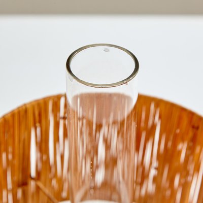 Lámpara de mesa de vidrio con pantalla de rafia.