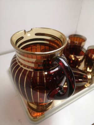 https://cdn20.pamono.com/p/g/1/4/1468158_d1cz1b9m0l/lemonade-pitcher-and-glasses-in-brown-glass-with-gilt-decor-1960s-set-of-8-5.jpg