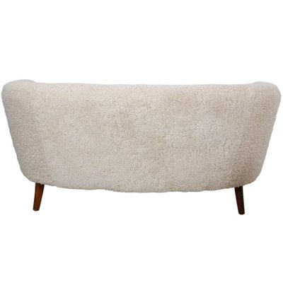 A Danish Two Seat Curved Sofa with Faux Sheepskin Upholstery A Danish Two Seat Curved Sofa with Faux Sheepskin Upholstery