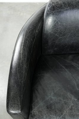 A modern, minimalist leather sofa in a gaming lounge setting.