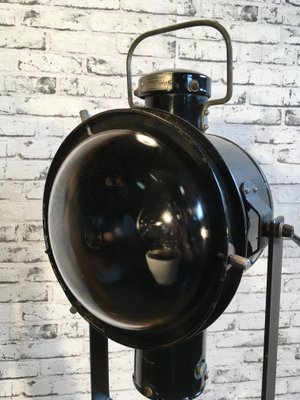 Schwarz emaillierte industrielle vintage Lampe auf hölzernem Dreibein Fuß von Napako Schwarz emaillierte industrielle vintage Lampe auf hölzernem Dreibein Fuß von Napako
