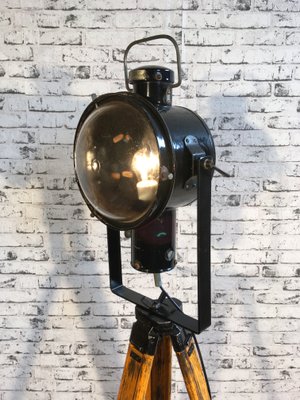 Schwarz emaillierte industrielle vintage Lampe auf hölzernem Dreibein Fuß von Napako Schwarz emaillierte industrielle vintage Lampe auf hölzernem Dreibein Fuß von Napako