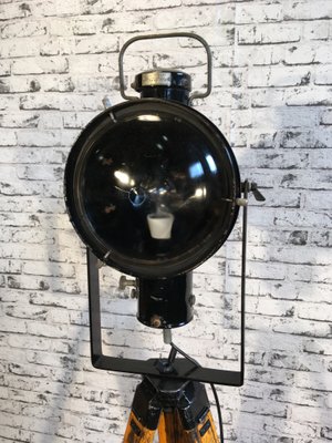 Schwarz emaillierte industrielle vintage Lampe auf hölzernem Dreibein Fuß von Napako Schwarz emaillierte industrielle vintage Lampe auf hölzernem Dreibein Fuß von Napako
