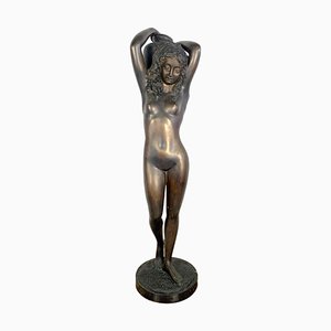 Scultura grande in bronzo di una giovane donna nuda che porta un'urna d'acqua, XX secolo