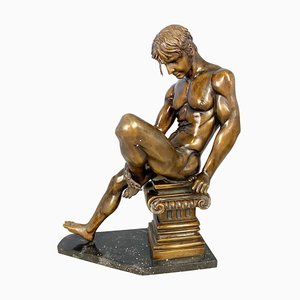 Luchador de bronce posando sobre un pedestal corintio, siglo XX