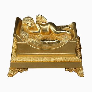 Tintero de bronce que representa un putto para dormir