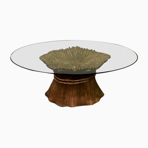 Tisch mit goldenem Keramikfuß und Kristallglasplatte.