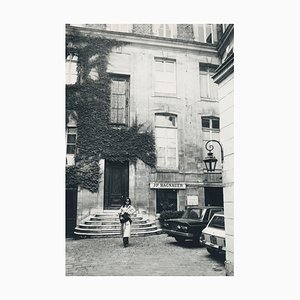 Jacky Onassis frente a una casa, años 50, fotografía en blanco y negro