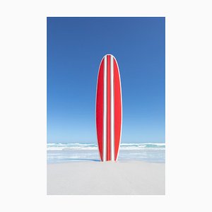 John White, Red and White Striped Retro Surfboard mit dem Ozean im Hintergrund, Fotopapier