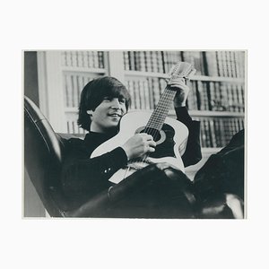 Fotografía en blanco y negro de John Lennon con guitarra, años 70