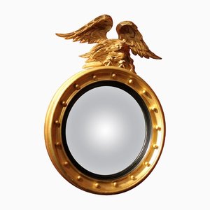 Espejo convexo italiano Regency redondo de madera dorada y ebonizada con águila tallada