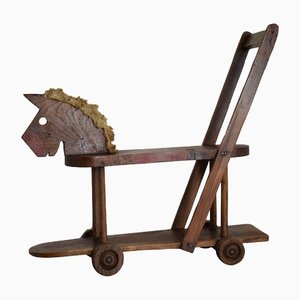 Caballo infantil antiguo de madera con ruedas