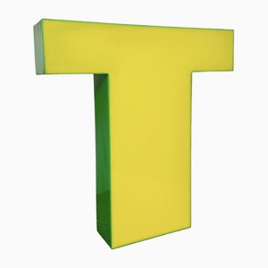 Letra T vintage iluminada en amarillo, años 70