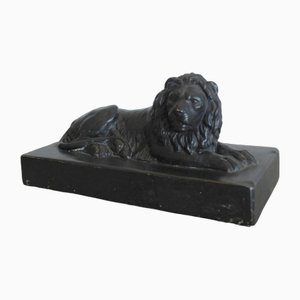 An English Ebonised Ceramic Lion, 1820s
