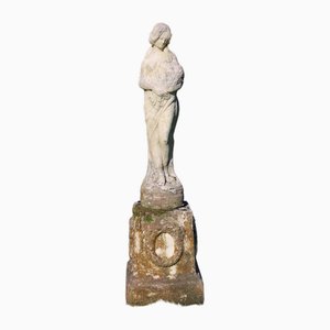 Statua da giardino vintage in pietra fusa di una signora su un basamento