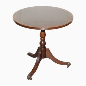 Mesa auxiliar vintage circular de caoba con ruedas de latón