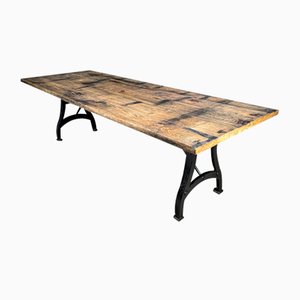 Mesa de comedor industrial con base de hierro fundido y hoja de madera