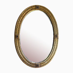 Espejo ovalado de metal dorado de principios del siglo XX