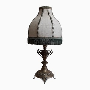 Lampada da tavolo con base in ottone decorato e paralume in tessuto segmentato