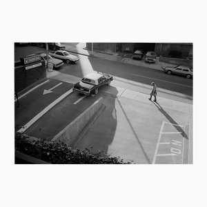 Michael Ormerod, Man Walking Past Parking Lot, Photographic Print