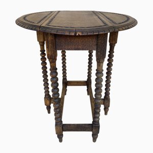 Mesa de centro plegable redonda de roble con tablero tallado y patas salomónicas, años 40