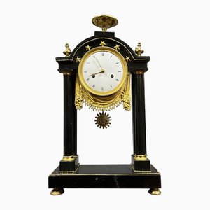 Pórtico Imperio de mármol negro y reloj de bronce dorado