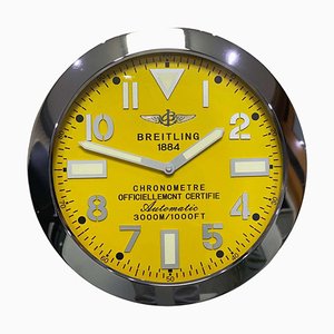Reloj de pared con cronómetro y bisel estriado con esfera amarilla luminosa de Breitling