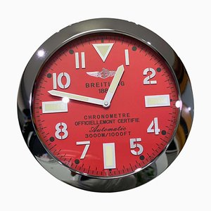 Orologio da parete cronometro con quadrante rosso e lunetta scanalata di Breitling