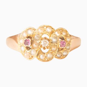 Anello in oro giallo 16 kt inizio 900 con diamante taglio rosetta, rubini e perle bianche