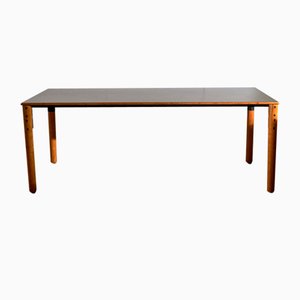 Tavolo grande in legno con piano in colore opaco ed elementi in metallo