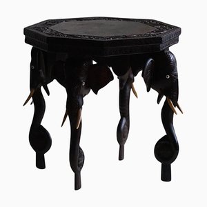 Tavolino in legno duro con 4 gambe a forma di testa di elefante, India, anni '20