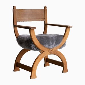 Vintage Danish Kurul Armchair in Oak and Sheepskin by Henning Kjærnulf, 1960s.