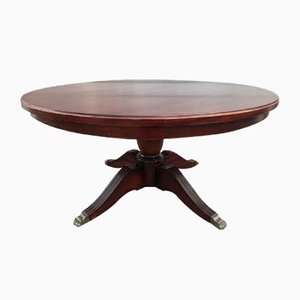 Mesa de centro estilo inglés grande redonda de caoba con una pata con patas de latón, años 50