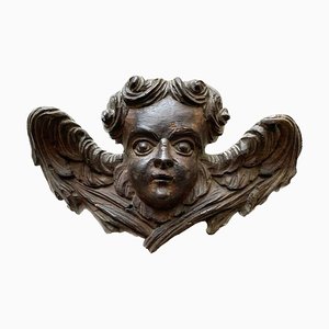 Escultura de ángel con cara de putto alado en madera tallada, 1700