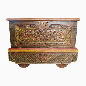 Cofre de comerciantes con ruedas en madera tallada y pintada