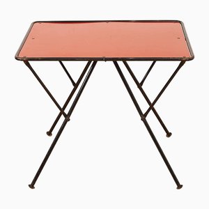 Mesa plegable de estructura de acero tubular pintada de negro, tablero de Pavatex con revestimiento de resina sintética en rojo, años 50