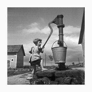 Ein Mädchen, das Wasser aus einem Brunnen holt, 1930, Fotodruck