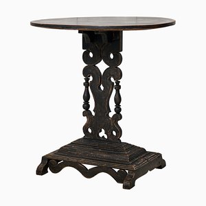 Mesa de centro sueca con pintura negra envejecida, superficie ovalada y base ornamentada