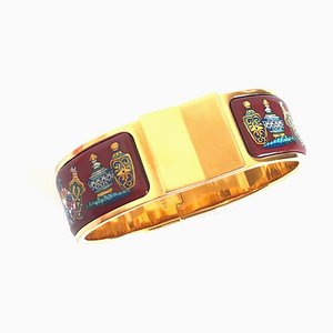 Brazalete dorado con esmalte cloisonné vintage y diseño de botella de perfume en rojo vino de Hermes