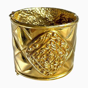 Brazalete vintage grande Matelasse de oro con la marca CC y motivos Arabesque de Chanel
