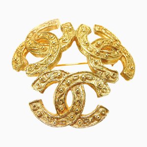 Broche Triple Coco Mark de metal dorado de Chanel, 1994
