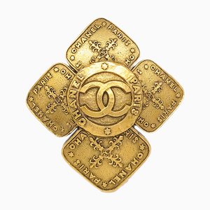 Spilla a forma di croce dorata di Chanel