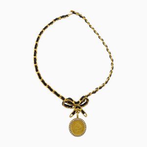 Collana con ciondolo a forma di medaglione con fiocco nero e strass in oro di Chanel