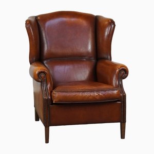 Sillón de orejas de cuero con gran pátina