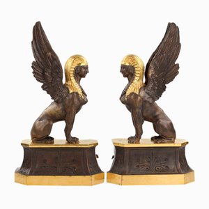 Patinierte und vergoldete Bronze Brennholzständer in Form von geflügelten Sphinxen, 2 . Set