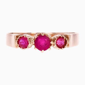 Anillo de trilogía de gemas rojas francesas de 18 kt en oro rosa, siglo XX