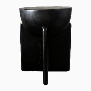 Taburete de madera de mango ennegrecida con asiento semicircular con base cruzada