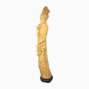 Statuetta in resina raffigurante una donna asiatica con decoro a forma di pavone, anni '20-'40