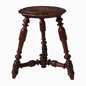 Taburete antiguo de madera con asiento tallado, década de 1900